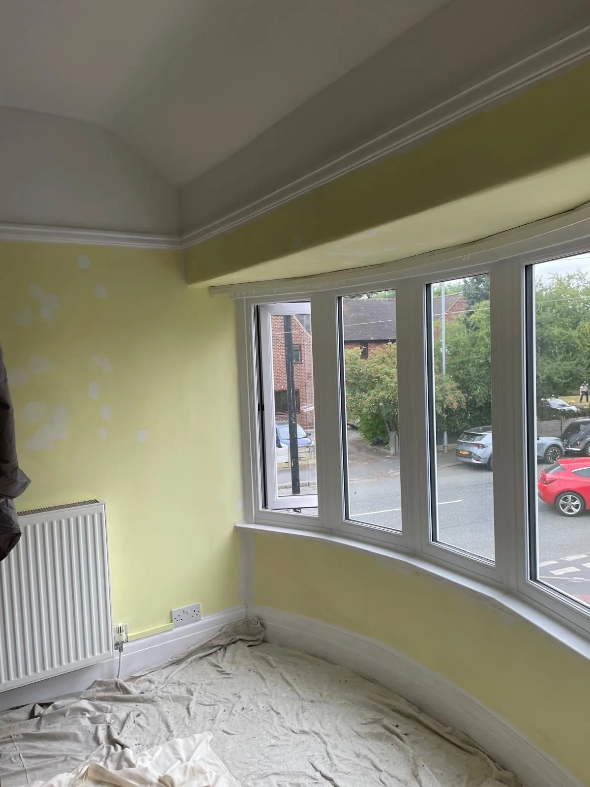 The same bay window room during preparation, walls filled and sanded before painting